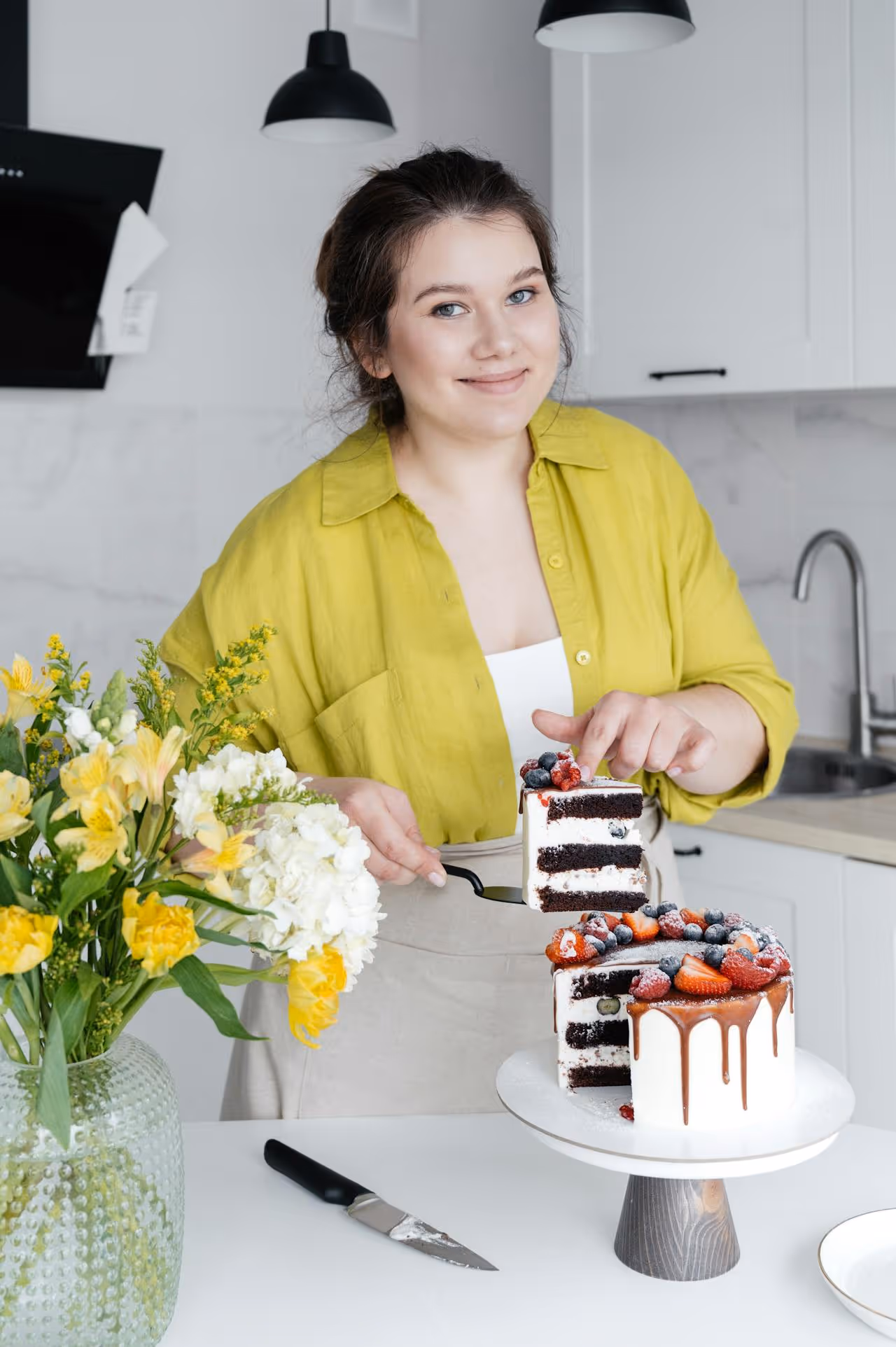 Mary segurando uma forma de biscoitos recém-assados com um sorriso gentil